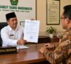 Gambaran poto Ilustrasi kepala sekolah memperlihatkan surat pernyataan resmi yang dikeluarkan Sekolah